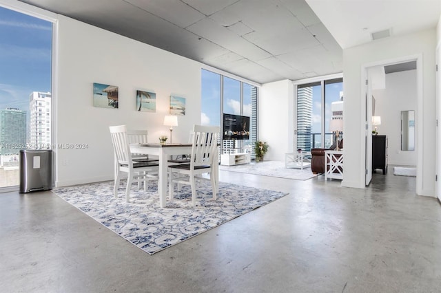 dining area featuring floor to ceiling windows and concrete floors