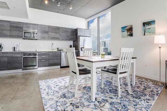 dining area featuring floor to ceiling windows and rail lighting