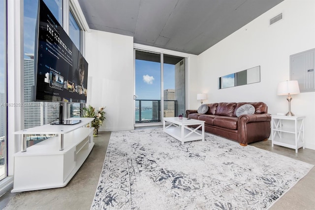 living room featuring concrete flooring and floor to ceiling windows