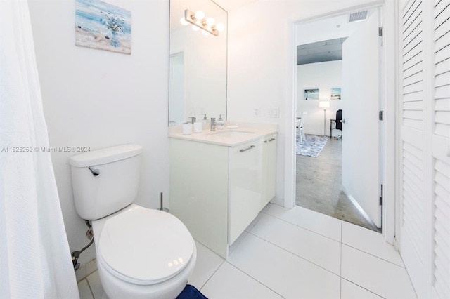 bathroom featuring vanity, tile patterned flooring, and toilet