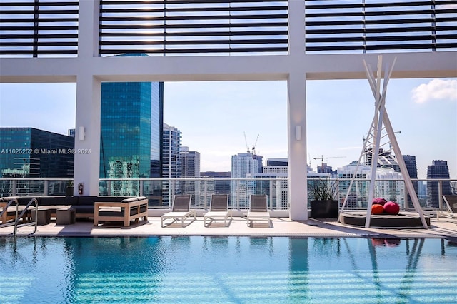 view of swimming pool featuring a water view, outdoor lounge area, and a patio