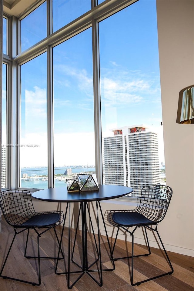 dining area featuring wood-type flooring and a water view