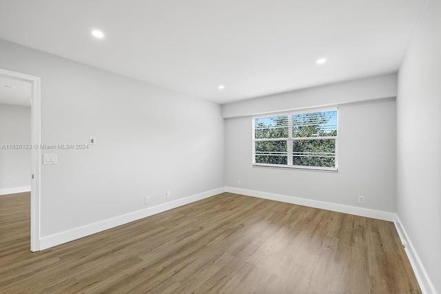 unfurnished room with hardwood / wood-style flooring