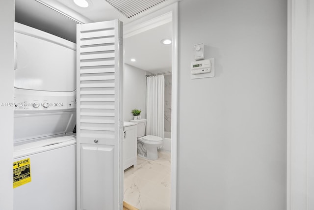 washroom featuring stacked washer / drying machine