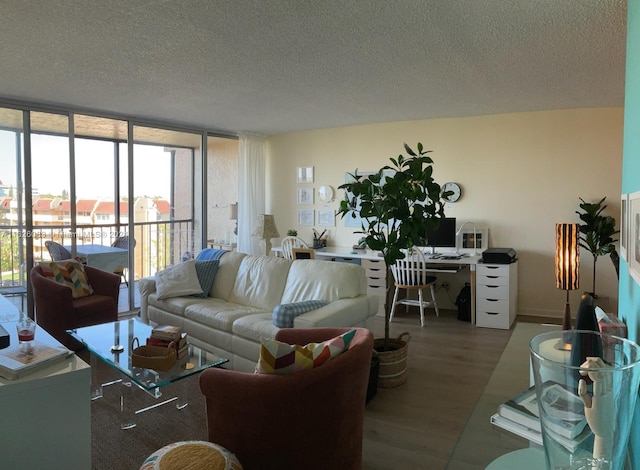 living room featuring a wall of windows, hardwood / wood-style floors, and a textured ceiling