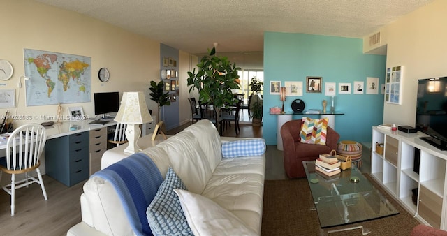 living room with a textured ceiling and wood-type flooring