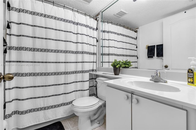 bathroom with tile patterned floors, toilet, vanity, and a textured ceiling