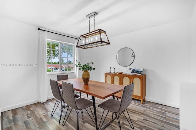 dining space featuring wood-type flooring and a chandelier