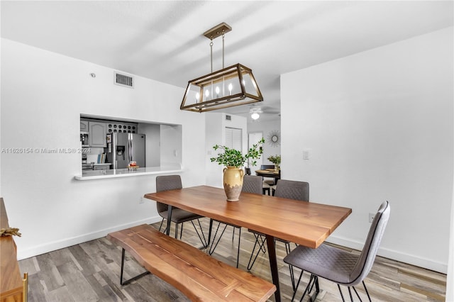 dining space featuring a notable chandelier and light wood-type flooring