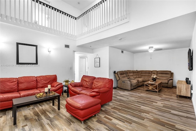 living room featuring a towering ceiling and wood-type flooring