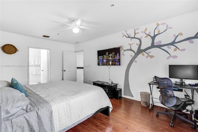 bedroom featuring ensuite bathroom, dark wood-type flooring, and ceiling fan