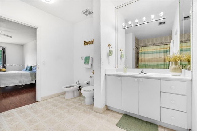 bathroom with vanity, tile patterned floors, ceiling fan, a bidet, and toilet