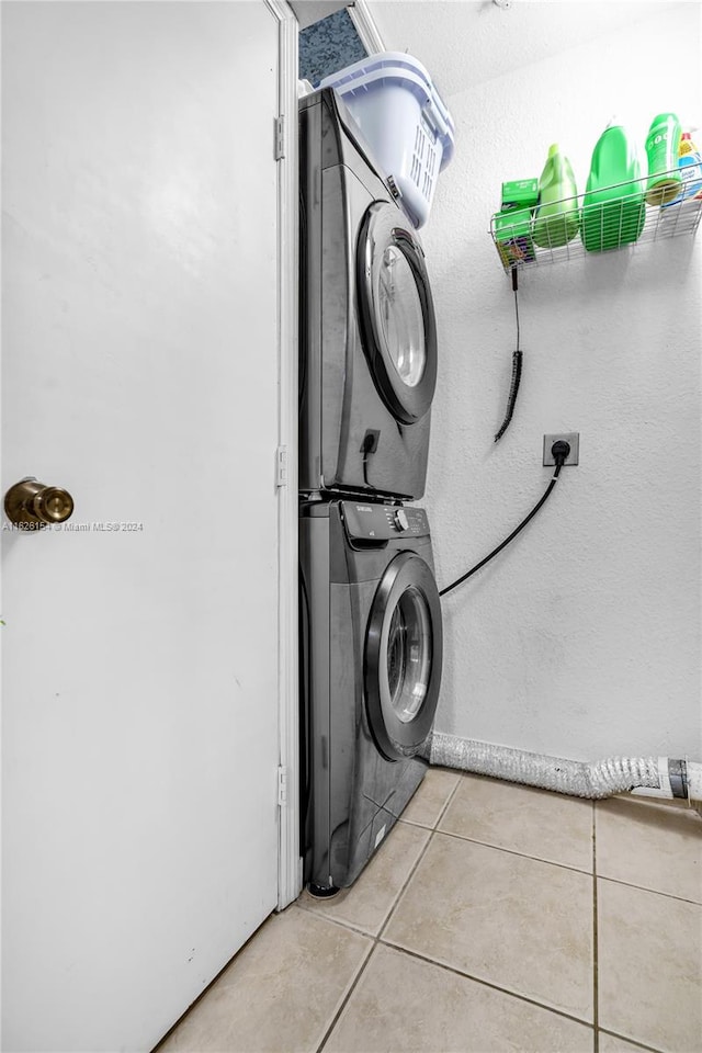 washroom featuring stacked washer / dryer and light tile patterned floors