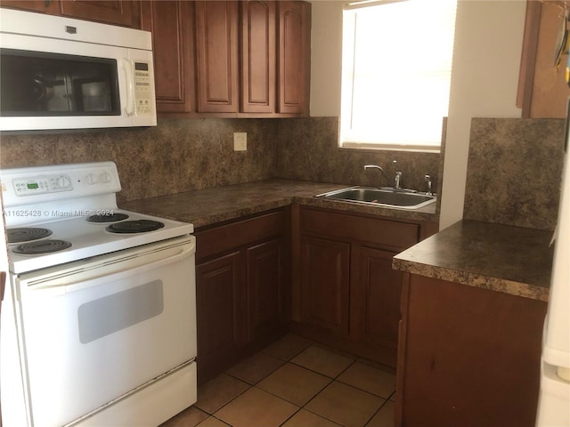 kitchen featuring light tile patterned flooring, decorative backsplash, white appliances, and sink