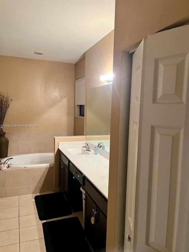 bathroom with tiled tub, vanity, and tile patterned floors