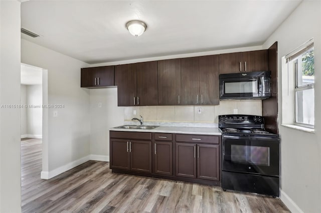 kitchen with light hardwood / wood-style floors, sink, dark brown cabinetry, and black appliances