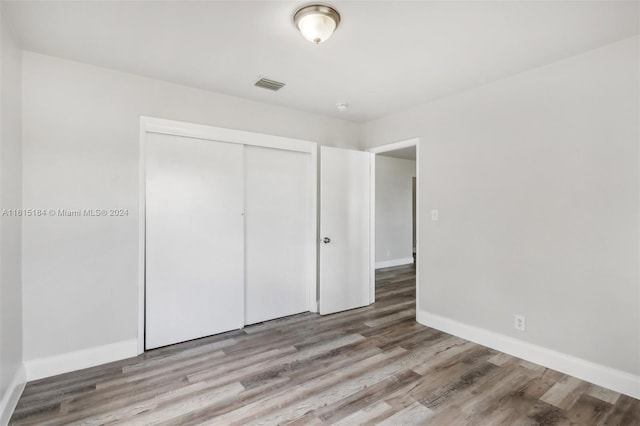 unfurnished bedroom with a closet and light hardwood / wood-style flooring