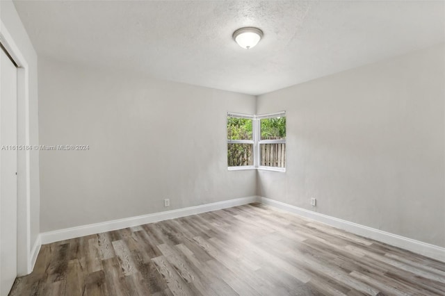 empty room featuring light hardwood / wood-style floors and a textured ceiling