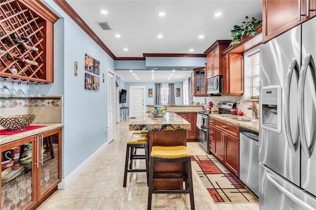 kitchen with visible vents, a breakfast bar, a wealth of natural light, appliances with stainless steel finishes, and a sink