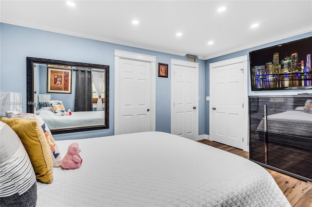 bedroom featuring recessed lighting, crown molding, baseboards, and wood finished floors