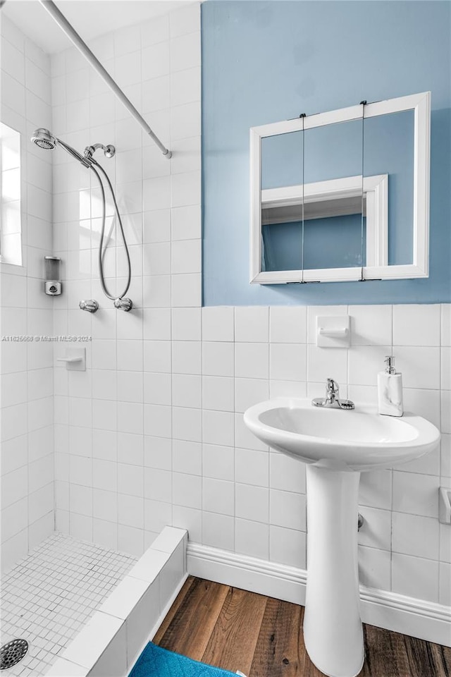 full bath featuring a stall shower, tile walls, and wood finished floors