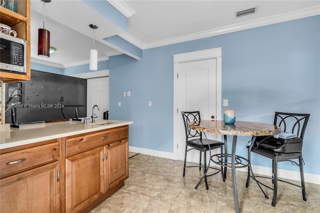 kitchen featuring stainless steel microwave, visible vents, baseboards, ornamental molding, and a sink