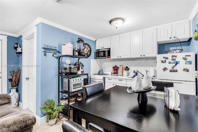 kitchen with backsplash, ornamental molding, light tile patterned floors, white appliances, and white cabinetry