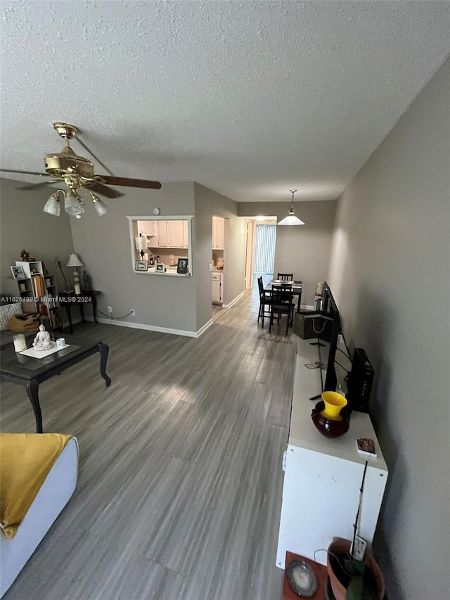 living room with wood-type flooring, a textured ceiling, and ceiling fan