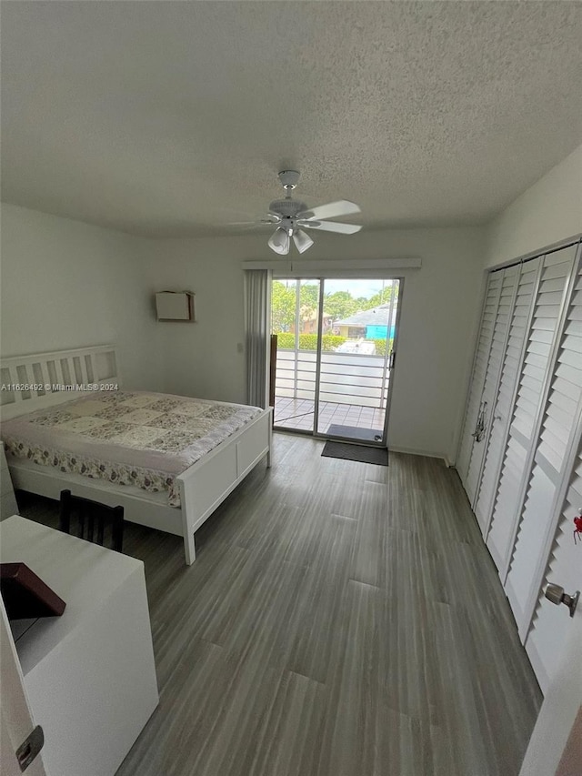 unfurnished bedroom featuring ceiling fan, access to outside, a textured ceiling, and hardwood / wood-style flooring