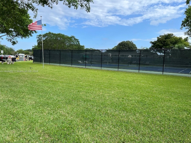 exterior space featuring tennis court and a lawn