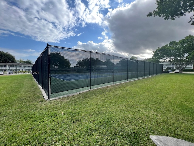 view of sport court featuring a lawn