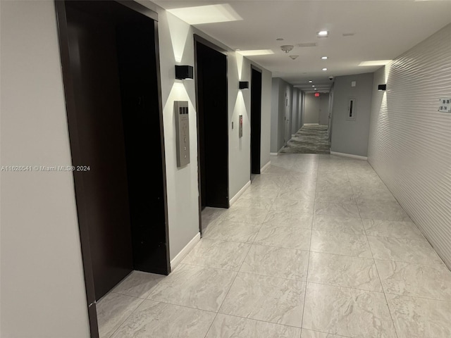 corridor featuring elevator and light tile patterned flooring