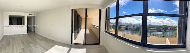 hallway featuring hardwood / wood-style flooring and a water view