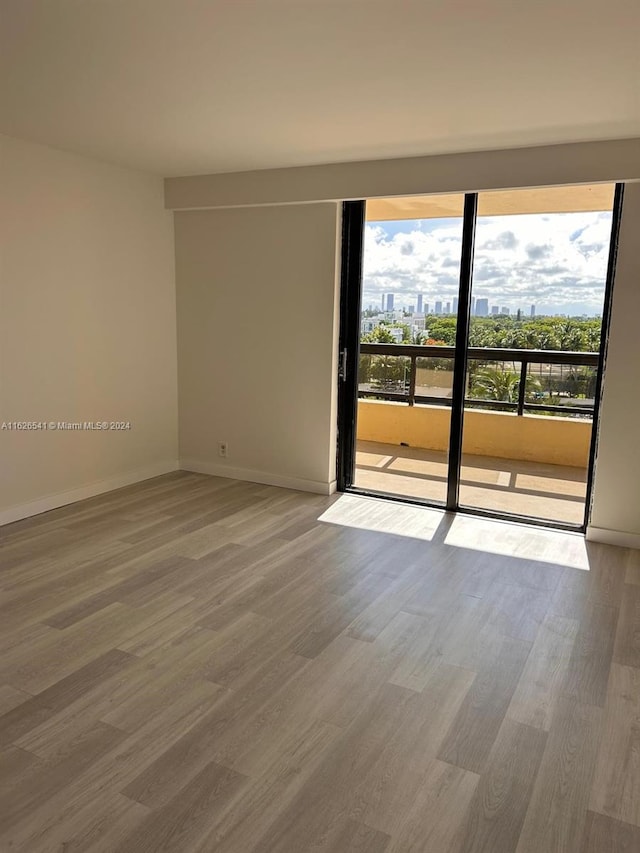 spare room featuring hardwood / wood-style flooring and plenty of natural light