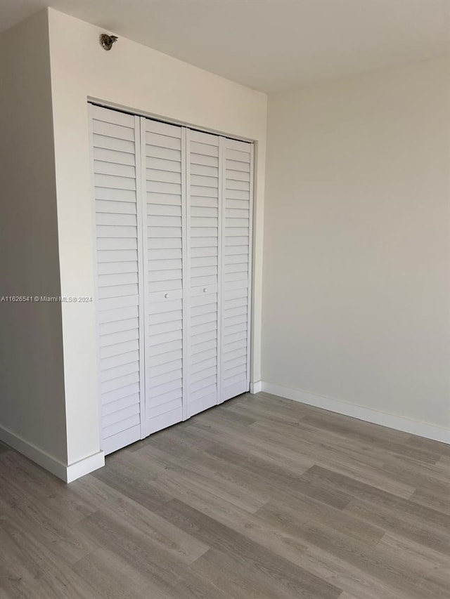 unfurnished bedroom with light wood-type flooring and a closet