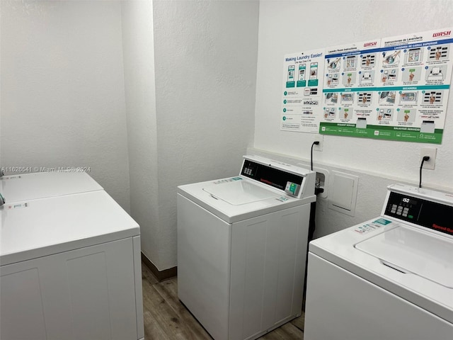 laundry area with separate washer and dryer and light hardwood / wood-style floors