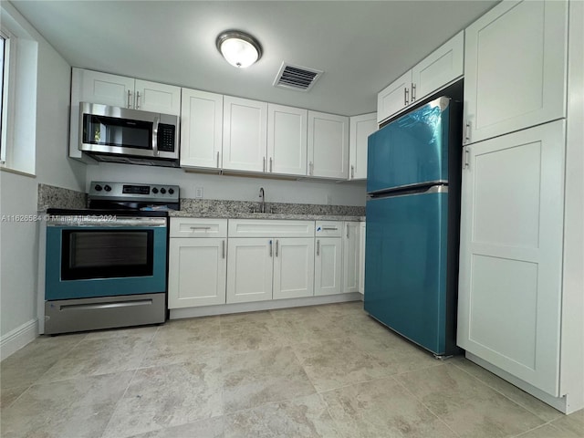 kitchen featuring white cabinetry, stainless steel appliances, sink, and light stone counters