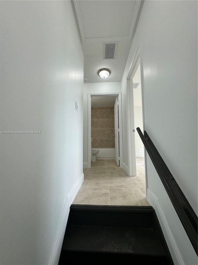 stairs featuring ornamental molding and tile patterned flooring