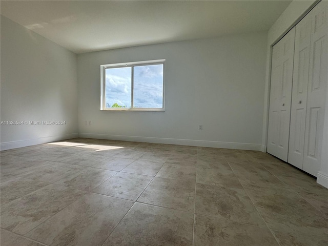 unfurnished bedroom with a closet and light tile patterned floors