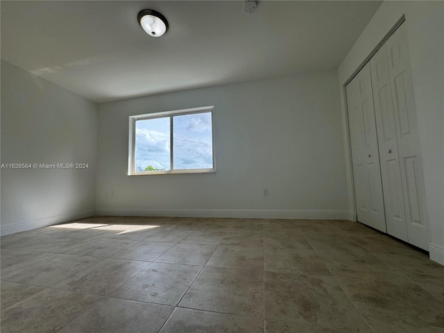 unfurnished bedroom featuring light tile patterned flooring and a closet