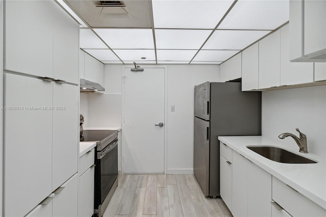 kitchen featuring white cabinetry, stainless steel refrigerator, light wood-type flooring, range with electric cooktop, and sink