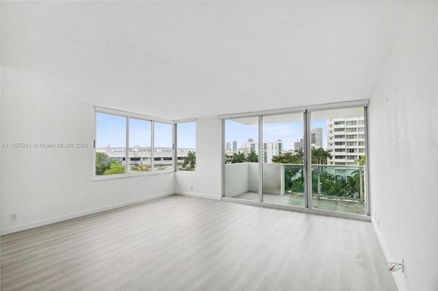 1200 W Ave Unit 515, Miami Beach, FL 33139 - unfurnished room featuring a city view, wood finished floors, and baseboards