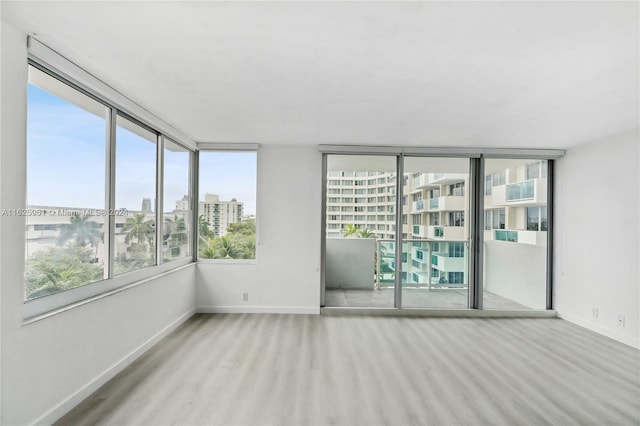 1200 W Ave Unit 515, Miami Beach, FL 33139 - spare room featuring baseboards, wood finished floors, and a view of city
