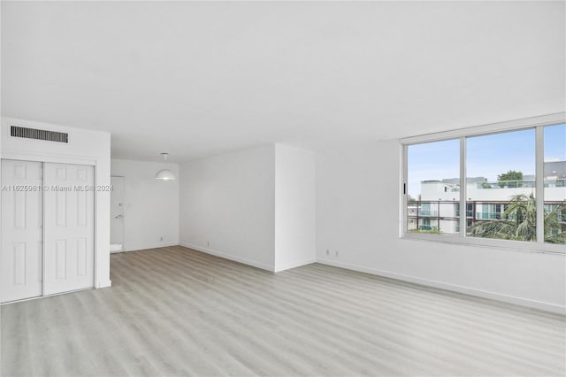 1200 W Ave Unit 515, Miami Beach, FL 33139 - unfurnished living room featuring light wood-style flooring and baseboards