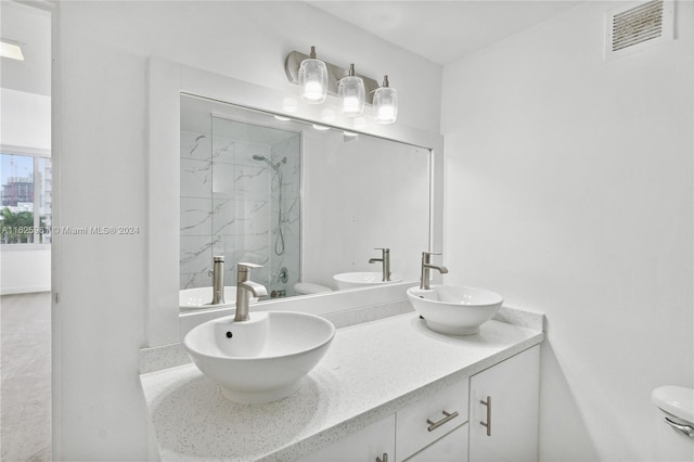 bathroom featuring toilet and double sink vanity