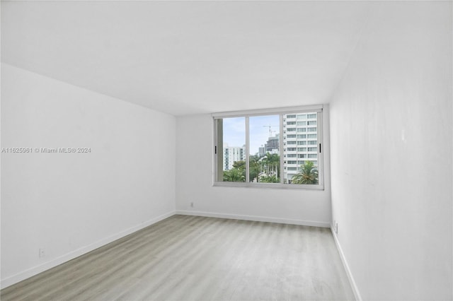 1200 W Ave Unit 515, Miami Beach, FL 33139 - unfurnished room featuring light wood-style flooring, baseboards, and a city view