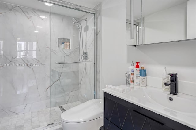 bathroom featuring toilet, vanity, and a shower with door