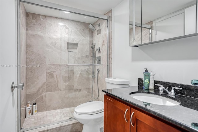 bathroom featuring toilet, vanity, and an enclosed shower