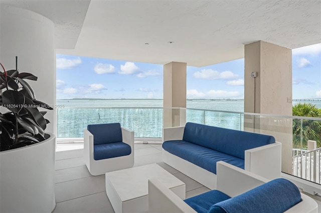 balcony with an outdoor living space and a water view