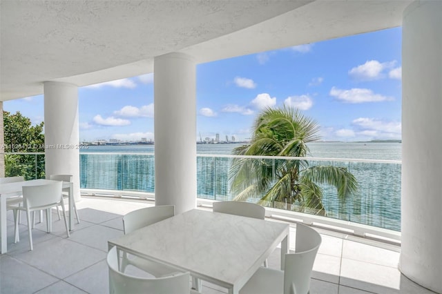 view of patio with a water view and a balcony